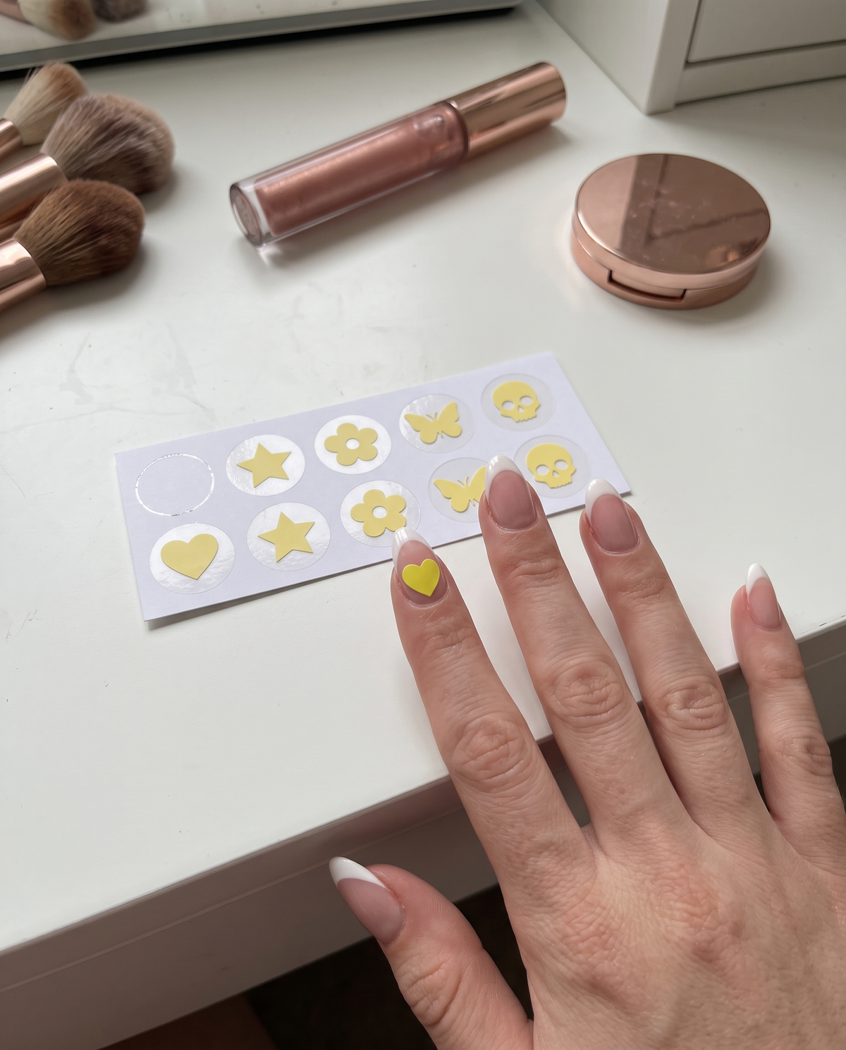 Lumeria sticker sheet on a vanity desk with a heart sticker on the index nail